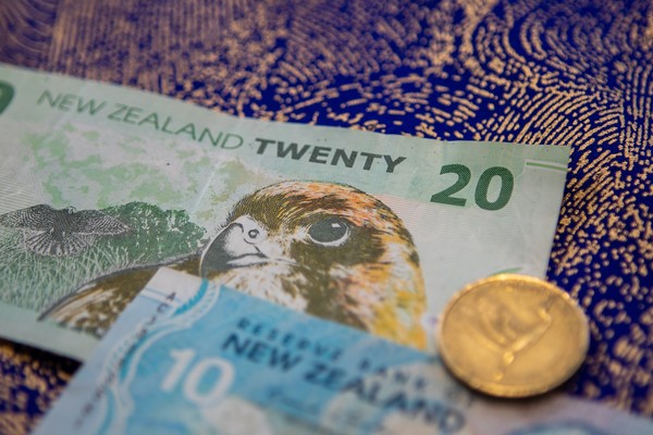 A $20 and a $10 New Zealand currency with a $2 coin